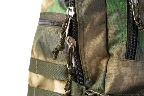 Bližnji pogled na kamuflažni nahrbtnik z zadrgami, pasovi in trakovi MOLLE.
