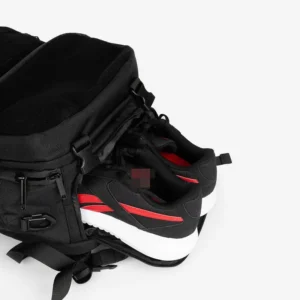 black tactical backpack with external pocket holding shoes.