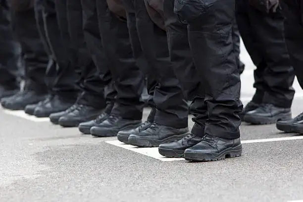 Uniformes noirs et bottes de policiers en ligne.