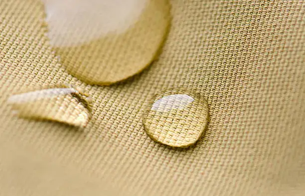 gocce d'acqua che si infrangono sulla giacca di nylon impermeabile.
