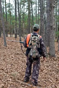 Male dressed in camoflauge in the forest