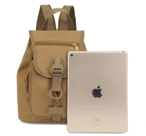 Vista frontal de una mini mochila táctica color canela junto a un iPad dorado.