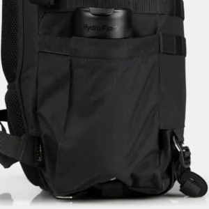 Bolsillo lateral de una mochila táctica negra que contiene una botella Hydro Flask.