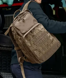 person bär khakifärgad taktisk ryggsäck för bärbar dator