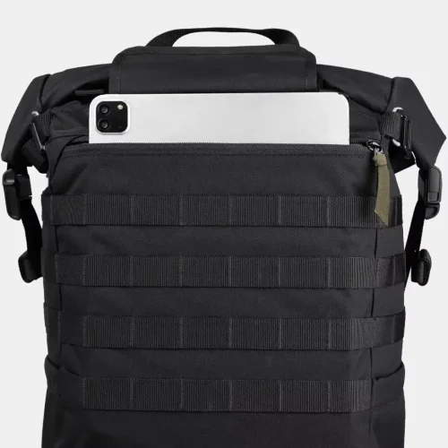 Compartimento superior de una mochila táctica negra con un teléfono y un portátil asomando.